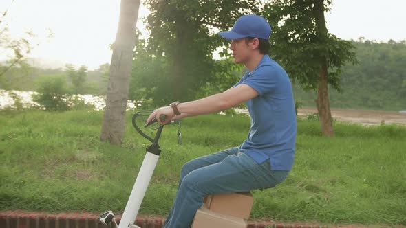 Delivery Asian Man Rides A Electric Scooter On The Road To Deliver Orders And Packages For Customers