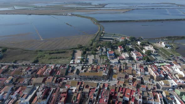 Aerial Drone Shot of Submerged Agricultural Fields Beside a Village with Blue Sky in the Background