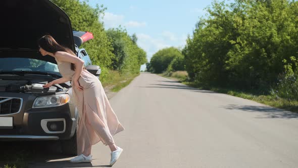 Beautiful Woman in Brown Polkadot Dress Has Car Breakdown on Road