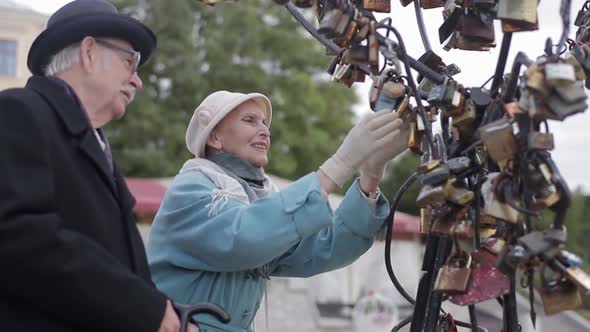 Old man shows wife locks of love.