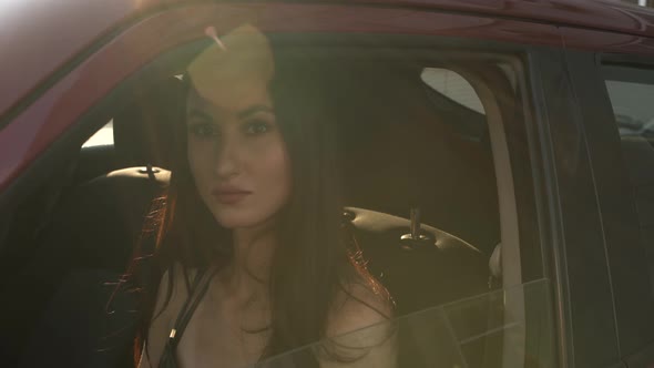 Close-up of a Girl Sitting in a Car Closing a Window