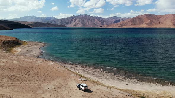 Aerial Over Off Road 4X4 Car Near Bulunkul Lake in Arid Mountains