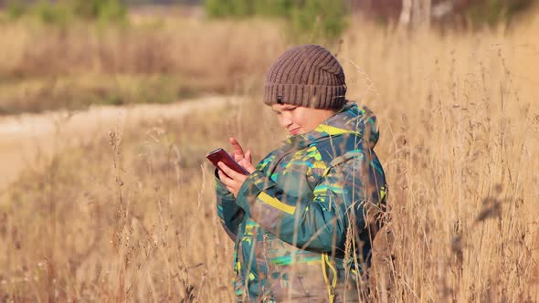 The Boy in the Tall Grass Plays on the Smartphone Online