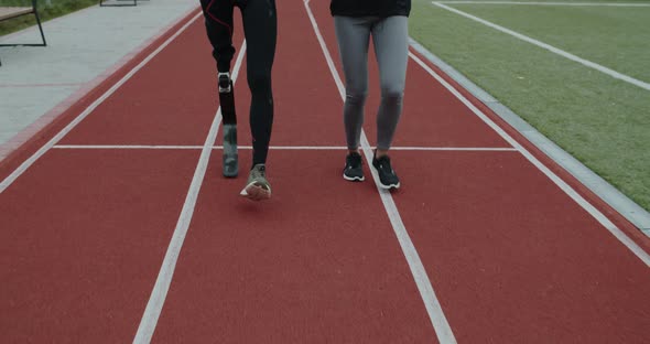 Crop View of Disabled Man and Sports Woman Jogging