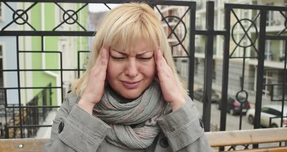 Close-up Portrait of Mature Caucasian Woman Suffering From Severe Headache. Senior Blond Retiree