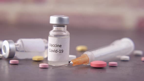 Close Up of Coronavirus Vaccine and Syringe on Black Background