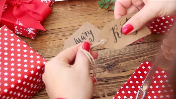 Hands attaching gift tag to Christmas present