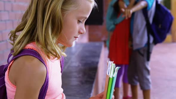 Schoolkid bullying a sad girl in corridor at school