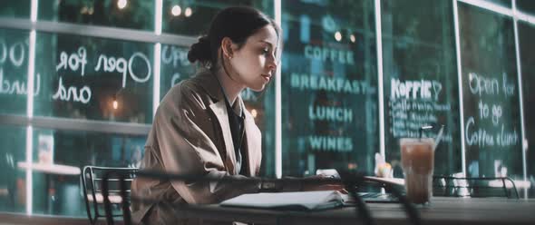 Business woman making notes in her notebook and typing on computer