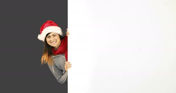 Beauty brunette in santa hat showing white poster 4k