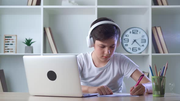 Pre Teen Cute Boy Pupil in Headphones Attending to Home Online School Class on His Computer Laptop