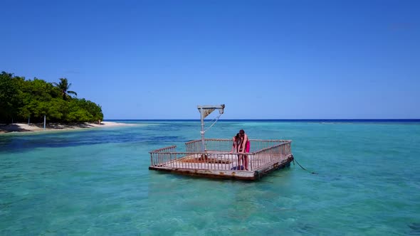 Romantic couple sunbathe on tranquil lagoon beach time by blue lagoon with white sand background of 