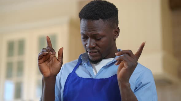 Overburdened African American Male Cook Rubbing Temples Having Headache Standing Indoors