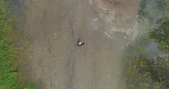 Aerial view of mature woman standing near a lake 