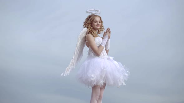 Happy Teenage Angel Girl Pray. Child with Angelic Character. Girl Dressed As an Angel on a Light