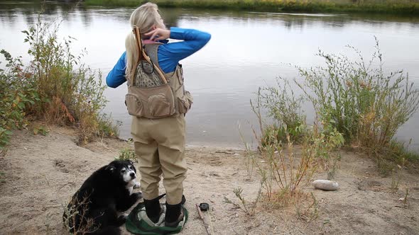 Woman Puts On Fly Fishing Vest