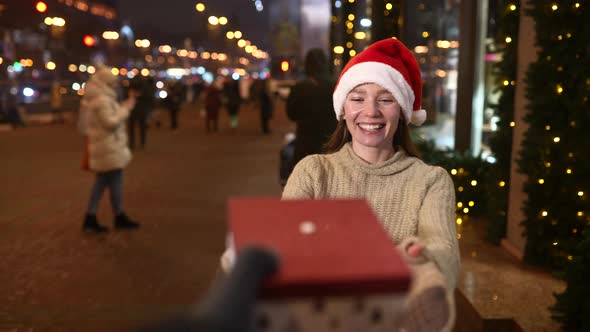 Young Woman Giving Box for you Outdoor