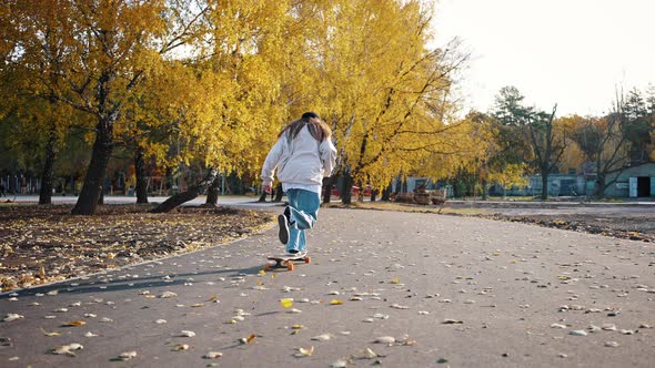 Walk in the Autumn Park on a Sunny Day on a Skateboard