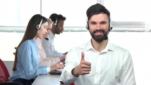 Young Handsome Man with Beard Showing Thumb Up in Office.