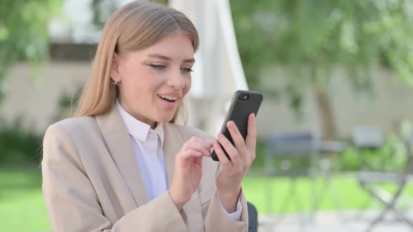 Outdoor Young Businesswoman Celebrating on Smartphone