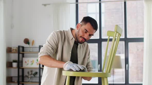 Man with Sponge Sanding Old Wooden Chair at Home