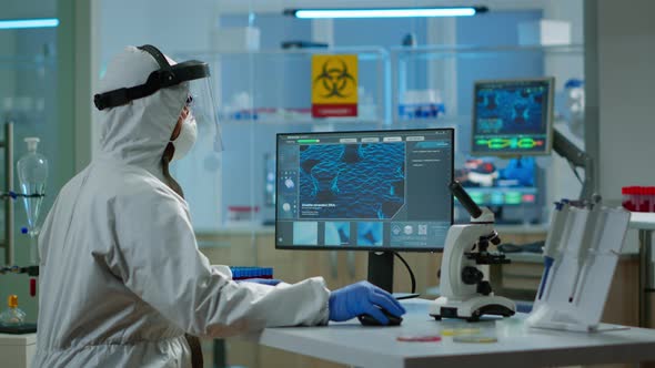 Man Scientist Working at Vaccine Development Typing on Pc in Coverall