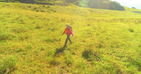 Flight Over Backpack Hiking Tourist Walking Across Green Mountain Field