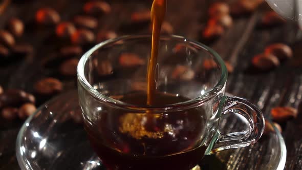 Black Coffee Is Poured Into a Glass Transparent Cup. Closeup