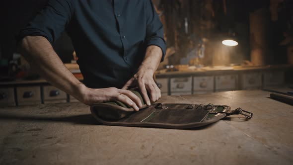 Tracking Shot of Unrecognizable Man Tailor Rolling Handmade Leather Case for Tools at Creative