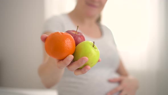 Pregnant Woman is Holding Fruits in Her Hand