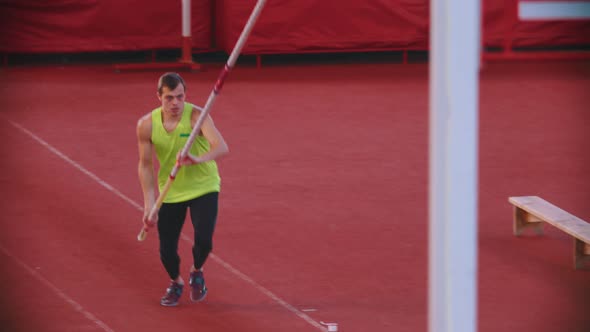 Pole Vault Training on the Stadium - an Athletic Man Performing His Jump Attempt