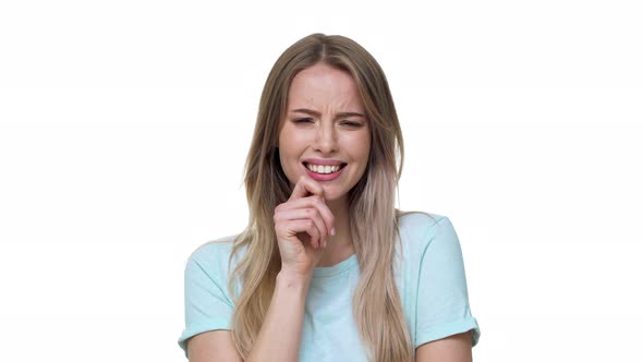 Portrait of Beautiful Woman 20s Wearing Basic Tshirt Biting Her Lips and Expressing Hesitation