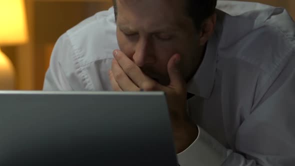 Tired Man Yawning, Reading Report on Laptop and Lying on Bed, Overworked Person