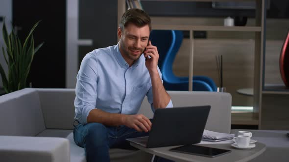 Business Man Using Laptop Computer Finishing Mobile Call in Remote Workplace