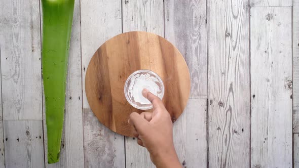 Fresh Aloe Vera Sliced and Liquid Gel in Plastic Container on White Background