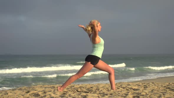 A young attractive woman doing yoga on the beach.