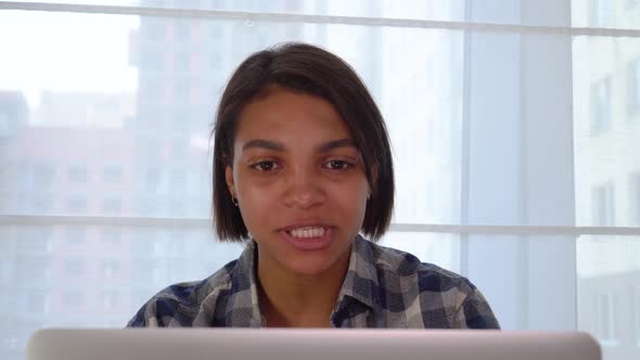 A Woman Communicates and Shouts at a Person Online Using a Laptop