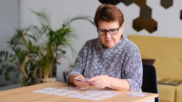 Senior Woman Playing Solitaire at Home