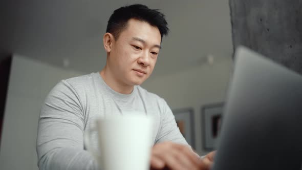 Asian handsome man working on laptop