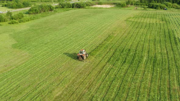 Aerial View Tractor Removes Grass From the Field