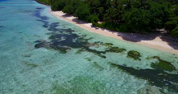 Beautiful drone tourism shot of a white paradise beach and blue sea background in 4K