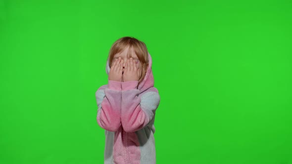 Little Blonde Child in Unicorn Costume Crying Wiping Tears with Her Hands on Chroma Key Background