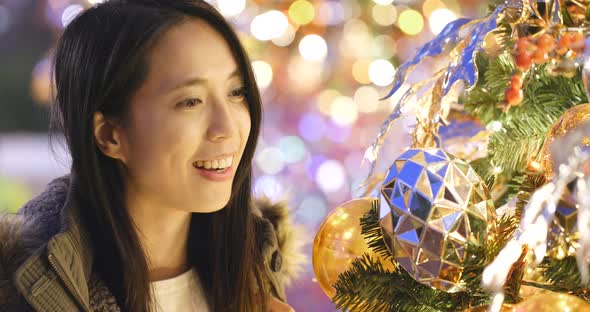 Asian Woman looking at the christmas tree decoration 