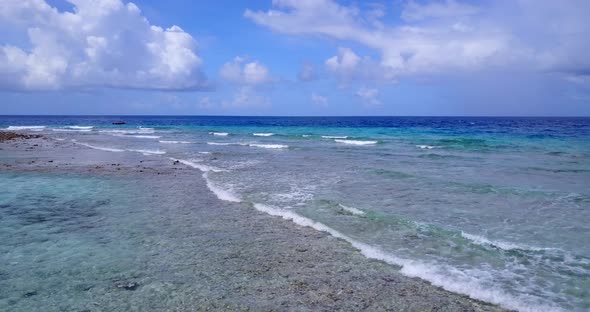 Tropical overhead clean view of a sandy white paradise beach and blue sea background in hi res 4K