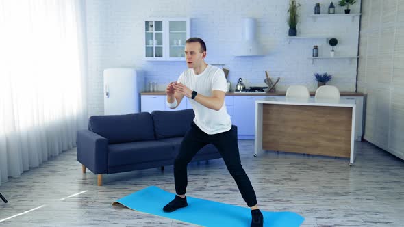 Strong athletic fit man doing exercises at home