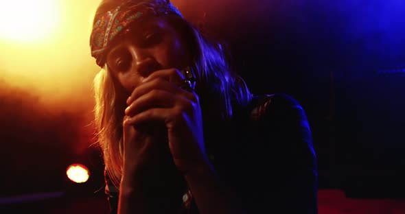 Woman playing harmonica at nightclub 4k