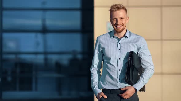Smiling Fashion Business Male Holding Briefcase Posing Outdoor at Sunset on Office Building