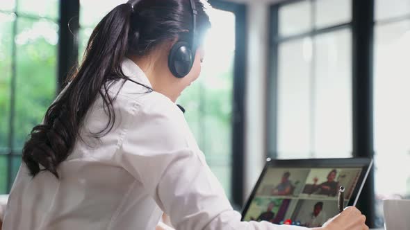 Asian business woman use laptop computer talking to colleagues team about plan in video conference.