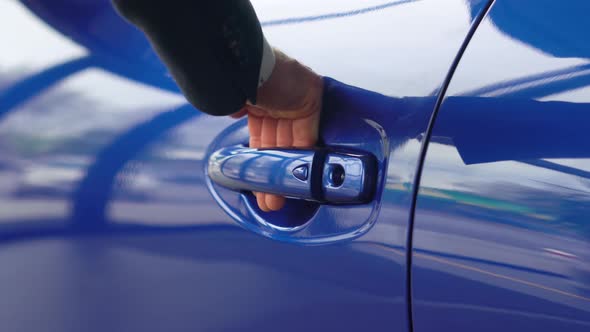 Closeup of Blue Car Door Handle Opened By Male Hand