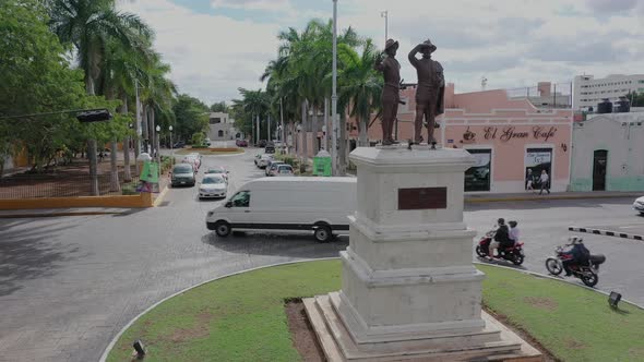 Slow aerial push in and over the monument to Francisco de Montejo and his son, showing the Paseo Mon